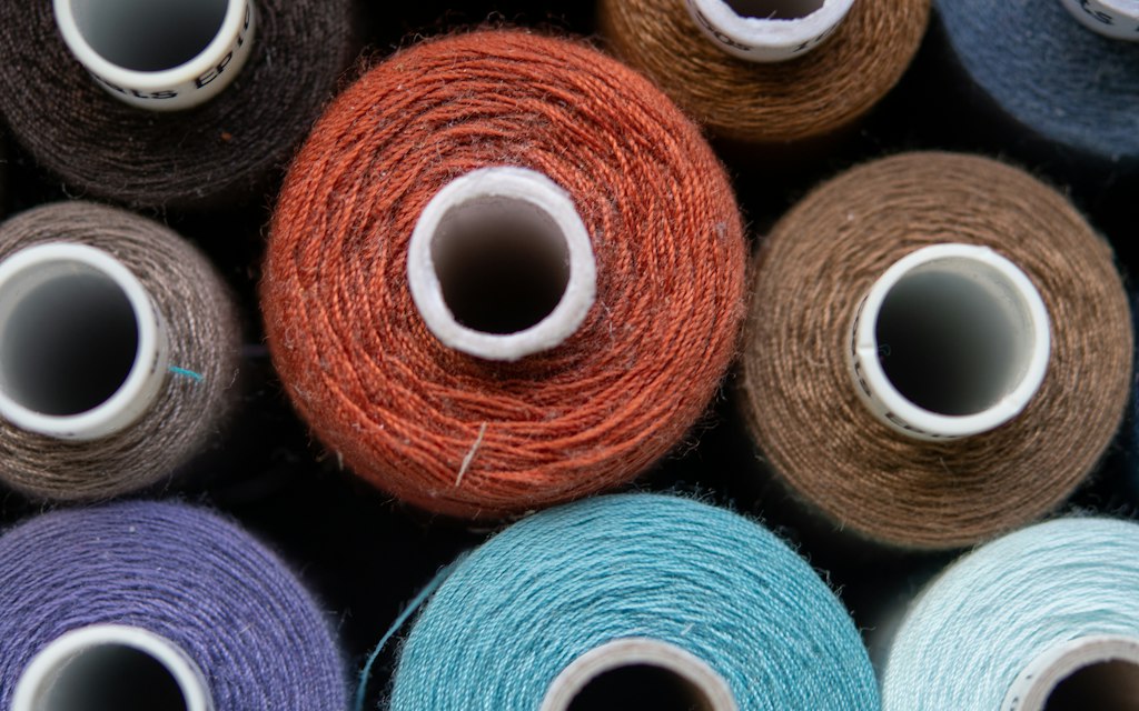 Rows of colorful thread spools used for bulk custom patch production