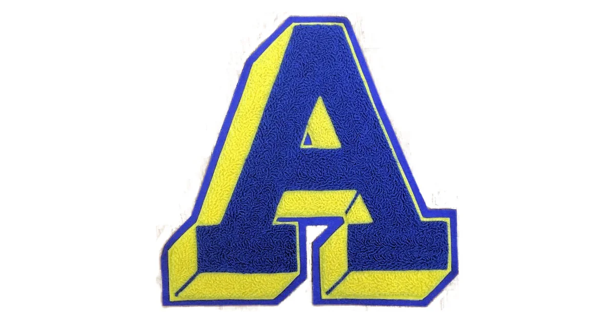 Close-up of a blue and gold chenille varsity letter patch showing the fuzzy, tufted yarn texture and layered felt border